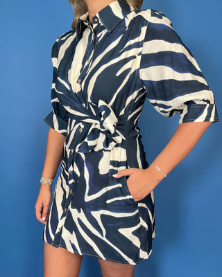 Navy and ivory abstract print button-down mini dress with puff sleeves, a collared neckline, waist tie, and side pockets.
