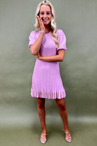 Woman wearing a purple dress against a green background