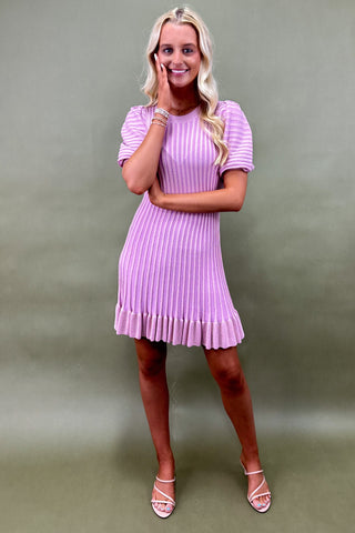 Woman wearing a light purple dress against a plain background