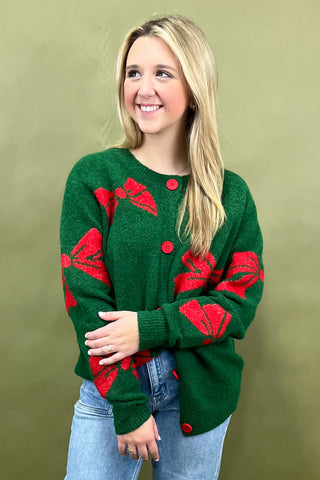 Woman wearing a green sweater with red patterns against a green background