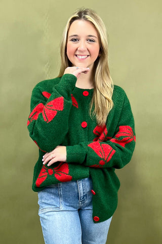 Woman wearing a green sweater with red patterns against a green background