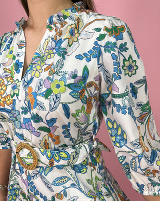 Colorful floral and butterfly patterned dress on a pink background