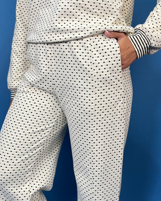 Ivory polka dot two-piece set with long sleeve pullover top, striped trim, and relaxed wide leg pants.