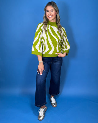 Lime green and ivory zebra print sweater with mock neckline, three-quarter sleeves, and relaxed fit.
