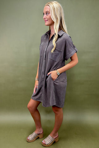 Woman wearing a gray dress against a green background