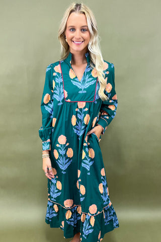 Woman wearing a green dress with floral pattern against a green background