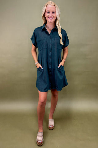 Woman wearing a teal dress against a green background