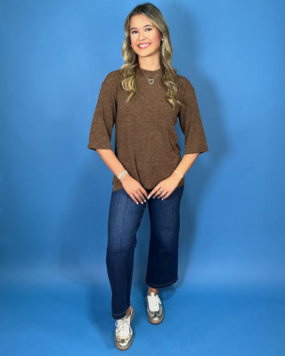 Chocolate brown textured knit top with round neckline, relaxed fit, and three-quarter length sleeves.