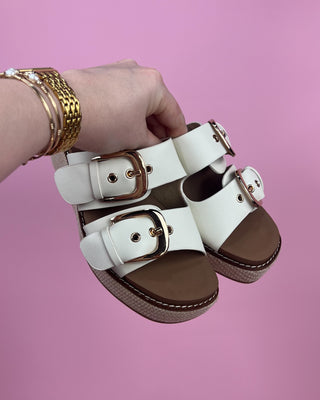 white strappy sandals on pink back ground
