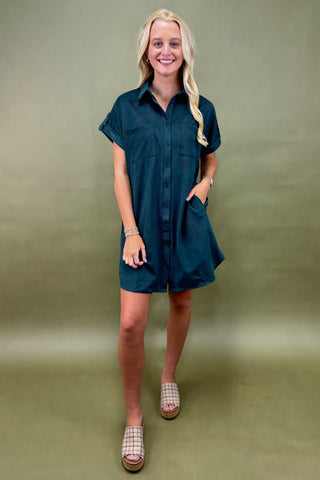 Woman wearing a teal dress against a green background