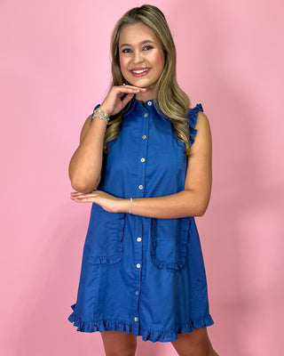 Woman wearing a blue dress against a pink background
