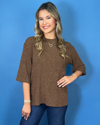Chocolate brown textured knit top with round neckline, relaxed fit, and three-quarter length sleeves.