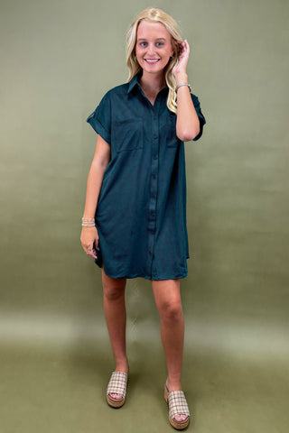 Woman wearing a teal dress against a green background