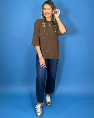 Chocolate brown textured knit top with round neckline, relaxed fit, and three-quarter length sleeves.