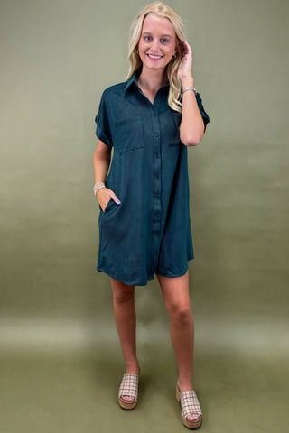Woman wearing a teal dress against a green background