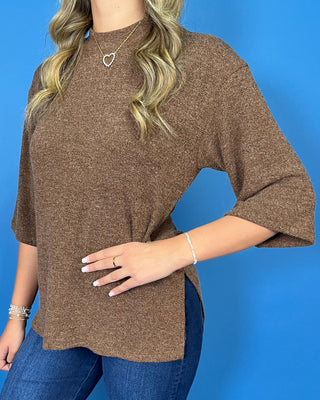 Chocolate brown textured knit top with round neckline, relaxed fit, and three-quarter length sleeves.