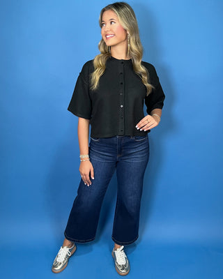 Black button-front short sleeve knit cardigan top with a crew neckline, relaxed fit, and cropped length.