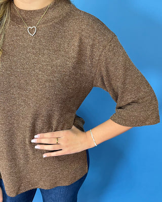 Chocolate brown textured knit top with round neckline, relaxed fit, and three-quarter length sleeves.