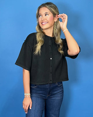 Black button-front short sleeve knit cardigan top with a crew neckline, relaxed fit, and cropped length.