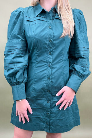 Teal dress with puffed sleeves worn by a person on a beige background