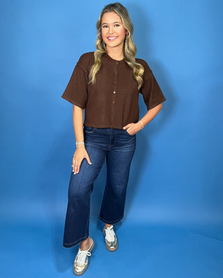 Chocolate brown button-front short sleeve knit cardigan top with a crew neckline, relaxed fit, and cropped length.