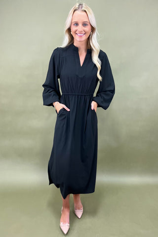 Woman wearing a black dress against a plain background