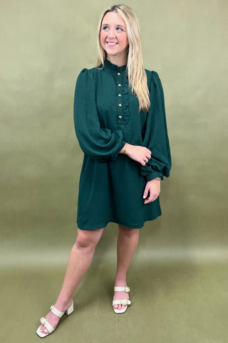 Woman wearing a green dress against a green background
