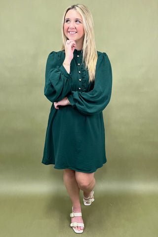 Woman wearing a green dress against a green background