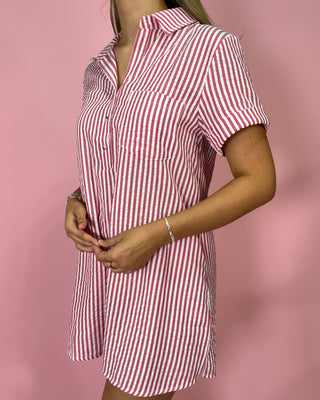 Red and white striped dress worn by a person on a pink background