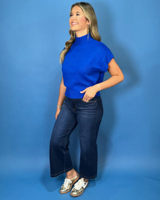 Royal blue turtleneck sleeveless knit sweater top with cap sleeves, ribbed trim, and a relaxed fit.