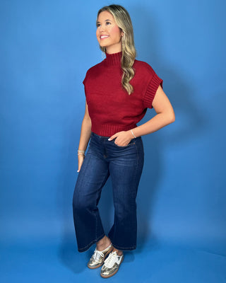 Burgundy mock neck sleeveless knit sweater top with cap sleeves, ribbed trim, and a relaxed fit.