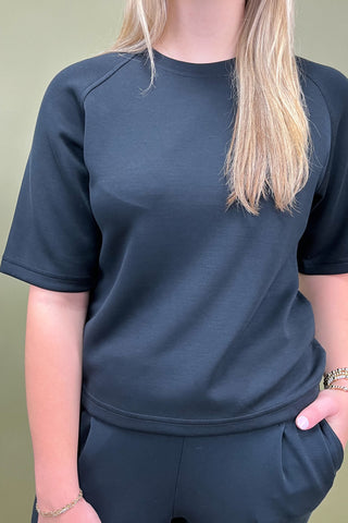 Person wearing a dark blue athletic outfit against a plain background