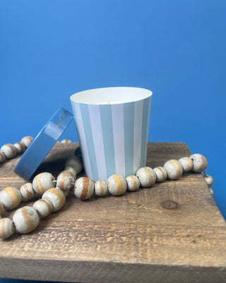 Capri Blue Volcano Artisan Gelato Cup Candle with blue and white striped vessel displayed on blue background. 