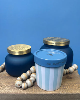 Capri Blue Volcano Artisan Gelato Cup Candle with blue and white striped vessel displayed on blue background. 