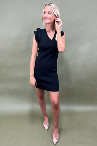 Woman wearing a black dress against a plain background