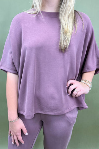 Person wearing a purple outfit with a plain background