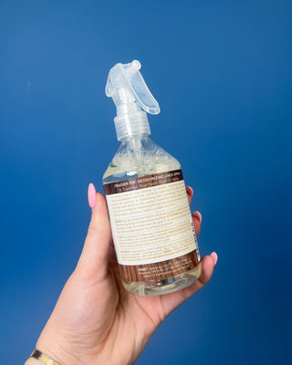 Thymes Frasier Fir 9 oz. Deodorizing Linen Spray displayed against a solid blue background.