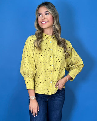 Mustard yellow polka dot button-down top with a pointed collar, statement puff sleeves, and a relaxed feminine fit.