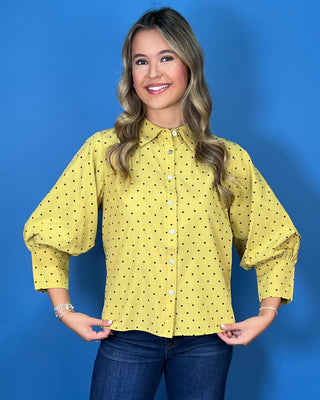 Mustard yellow polka dot button-down top with a pointed collar, statement puff sleeves, and a relaxed feminine fit.