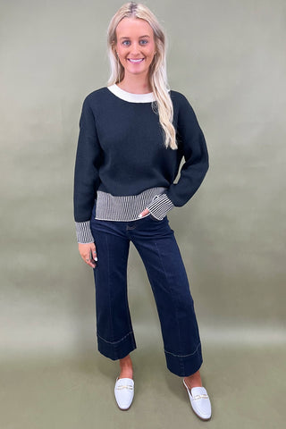 Black knit sweater with striped trim styled with dark wide leg cropped jeans and white loafers, casual fall outfit