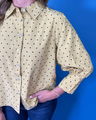 Mustard yellow polka dot button-down top with a pointed collar, statement puff sleeves, and a relaxed feminine fit.