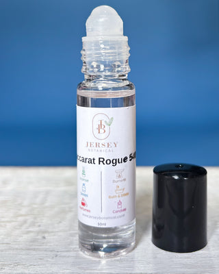 Baccarat Rouge roll-on perfume bottles displayed on a wooden surface with a blue background.