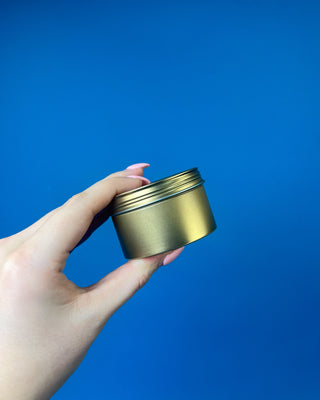 Thymes Frasier Fir Travel Tin Candle displayed on a solid blue background. 