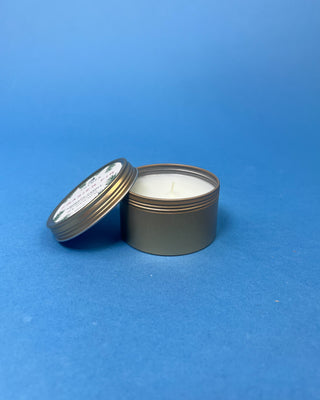 Thymes Frasier Fir Travel Tin Candle displayed on a solid blue background. 