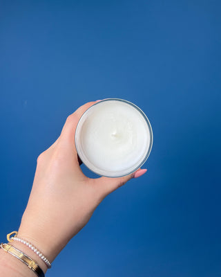 Thymes Frasier Fir Tidings 6.5 oz. candle in decorative gift box displayed on a solid blue background. 