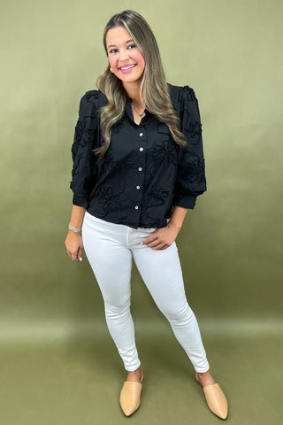 Woman wearing a black shirt and white pants on a green background