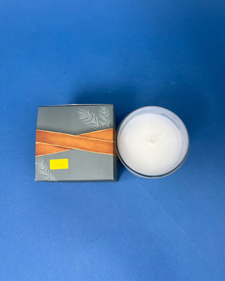 Thymes Frasier Fir Tidings 6.5 oz. candle in decorative gift box displayed on a solid blue background. 
