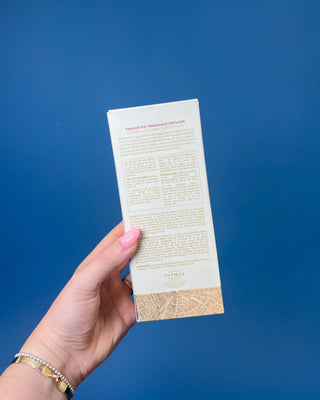 Thymes Frasier Fir Petite Gold Diffuser with reeds displayed on a solid blue background. 