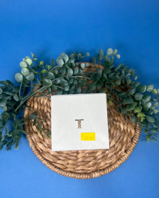 Thymes Frasier Fir Petite Gold Diffuser with reeds displayed on a solid blue background. 