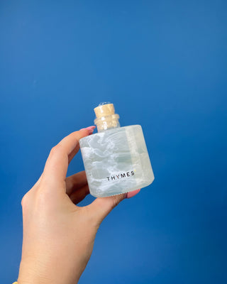 Shop the Thymes Frasier Fir Tidings Petite Reed Diffuser with marbled glass vessel and iconic evergreen fragrance for flameless holiday scent.